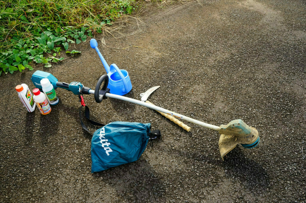 電動刈り払い機と鎌(カマ)、除草剤、ジョウロと除草道具一式