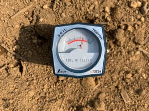 土壌酸度計（土壌pH測定器）を土壌に埋設し実際に使っている様子